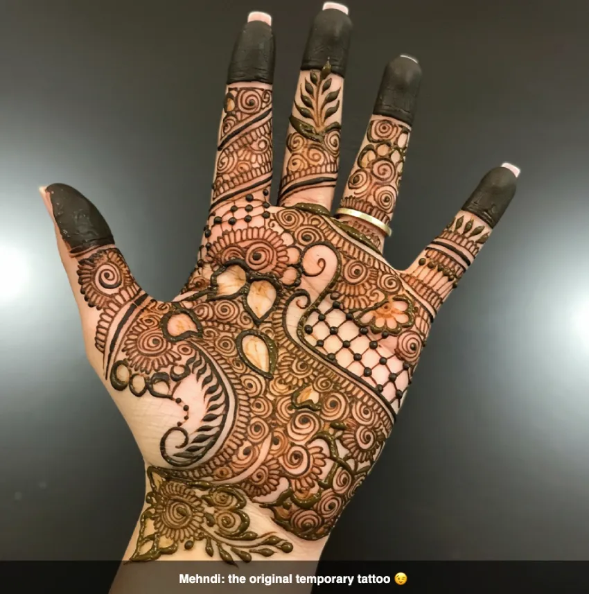 350+ Perfect Mehndi Captions for Instagram with Emojis 18 Hand with clever mehndi designs, suggesting wit, with the caption 'Mehndi: the original temporary tattoo π'.