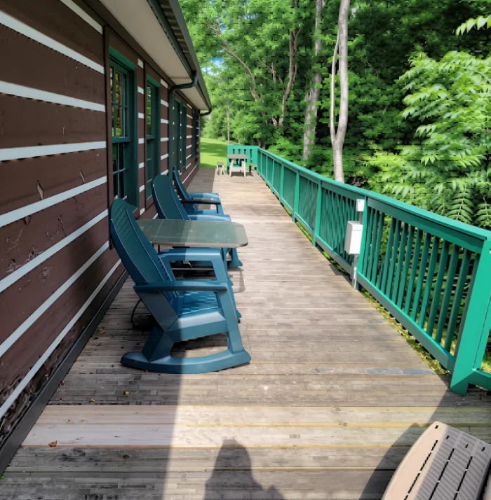 Affordable and Cosy Cabins in Pigeon Forge You’ll Love 5 Private wooden deck at Mountain Angel cabin in Pigeon Forge with rocking chairs and forest views.