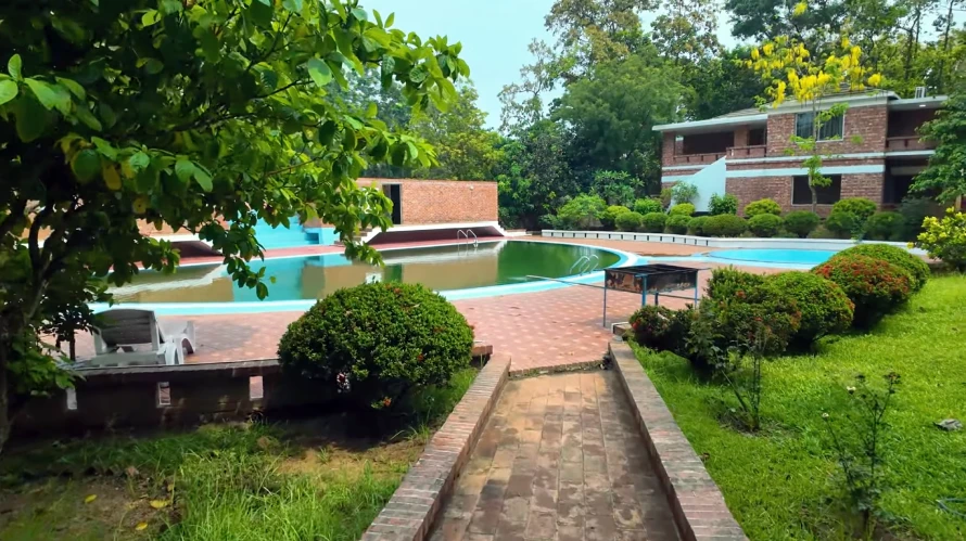 Best Resorts for Couples in Gazipur, Dhaka 24 Peaceful Poolside Area Surrounded By Greenery And Red Brick Buildings At Rangamati Waterfront Resort In Gazipur, Bangladesh, With Lounge Chairs And Landscaped Gardens.
